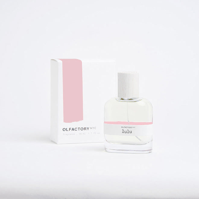 A minimalist desk with a lamp, plant, laptop, notebooks, and coffee beans.