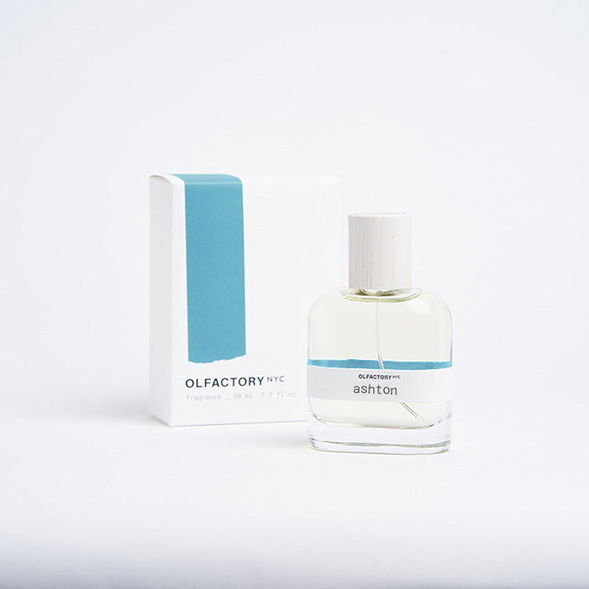 A minimalist desk with a lamp, plant, laptop, notebooks, and coffee beans.